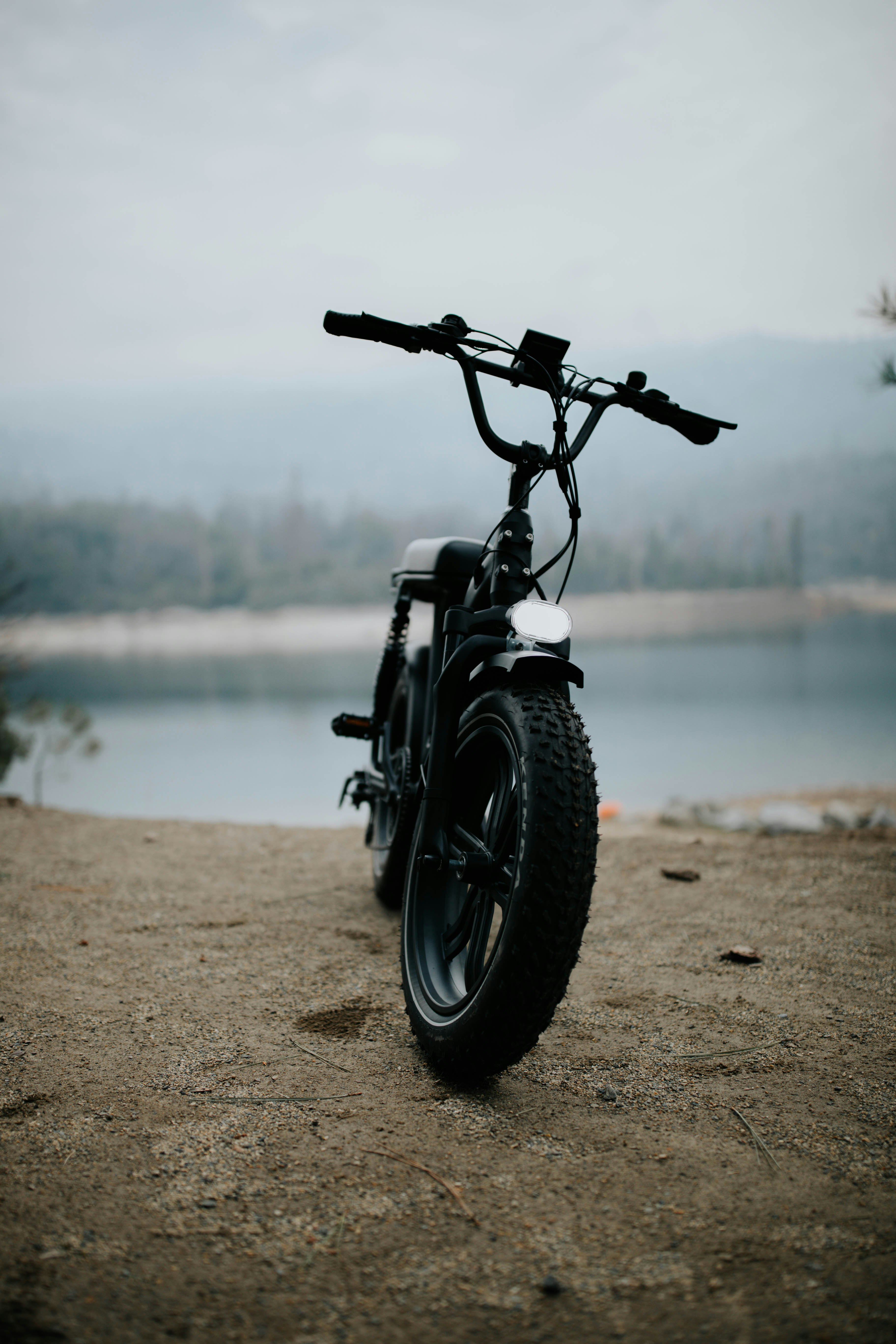 black motorcycle parked on beach shore during daytime